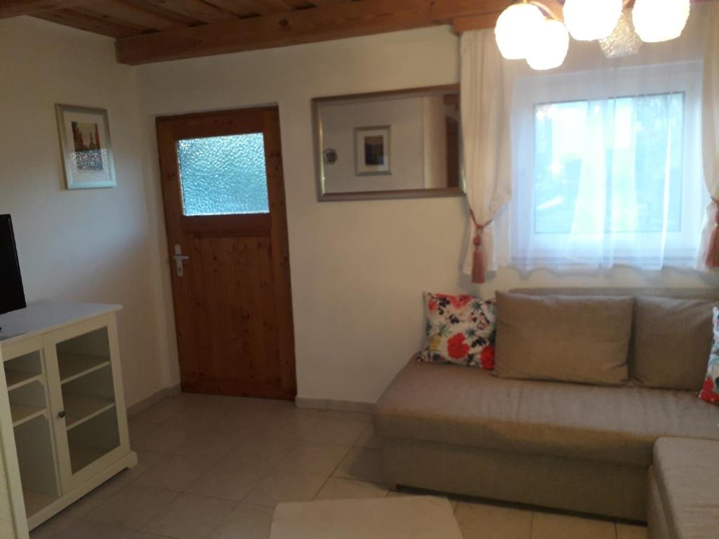 salon z kanapą i oknem w obiekcie Ferienhaus Weingarten Eisenberg w mieście Vaskeresztes
