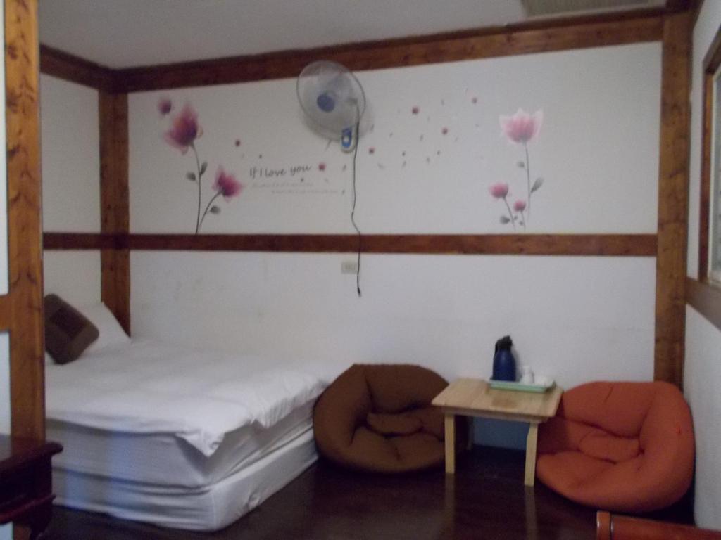a bedroom with a bed with flowers on the wall at Share B&amp;B in Puli