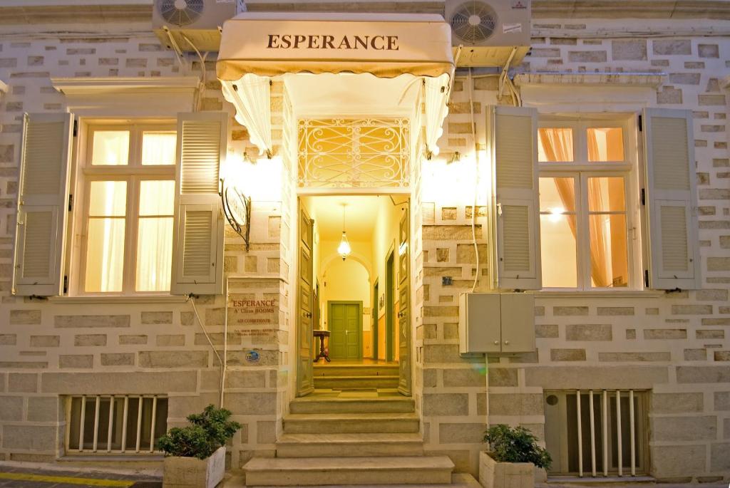 a building with a yellow door and windows at Esperance 2 in Ermoupoli