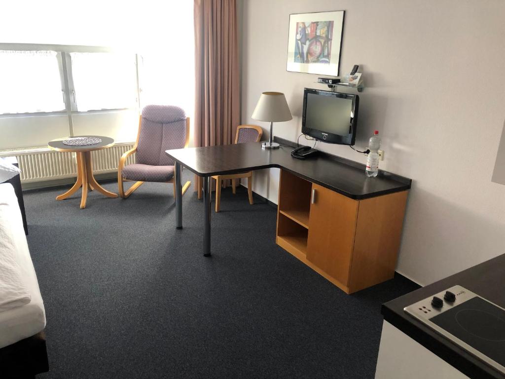 a hotel room with a desk with a tv on it at Apartment 31 in Sindelfingen