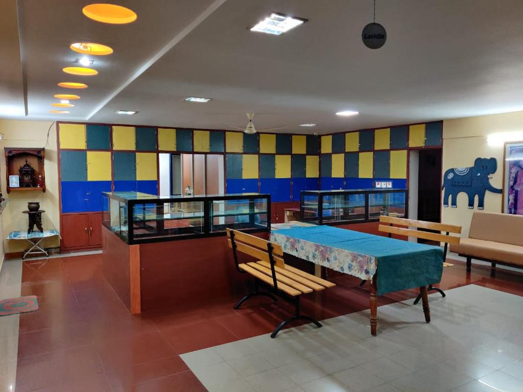 um quarto com mesa de pingue-pongue e bancos em Bedspace Living em Udupi