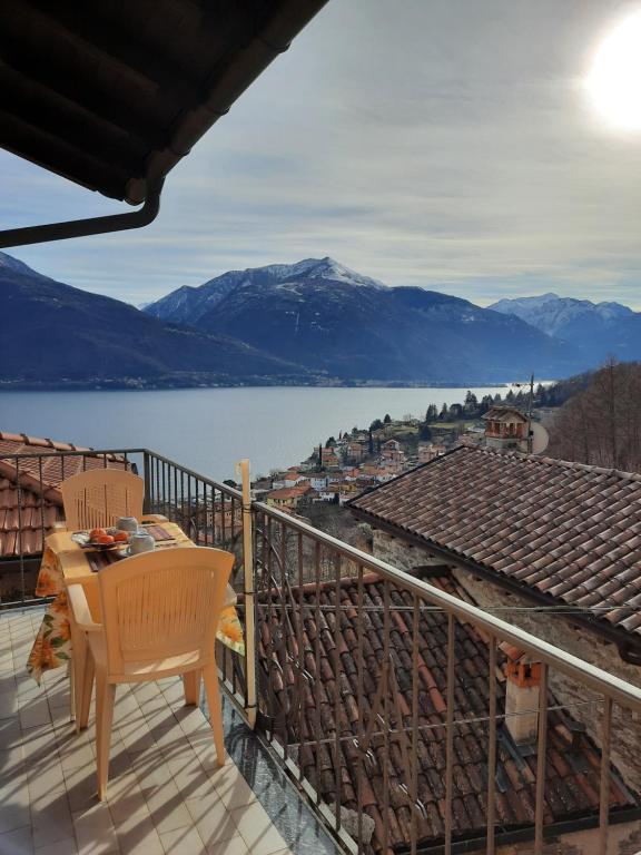a table and chair on a balcony overlooking a lake at Casa Emma in Pianello Del Lario