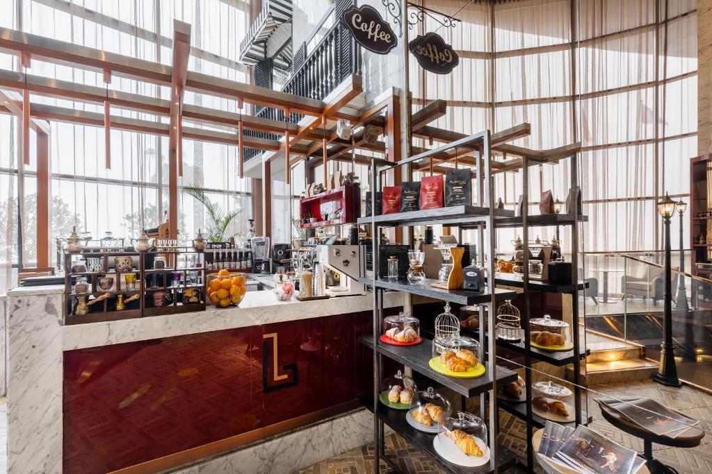 a restaurant with a counter with plates of food at Paramount Hotel Dubai in Dubai