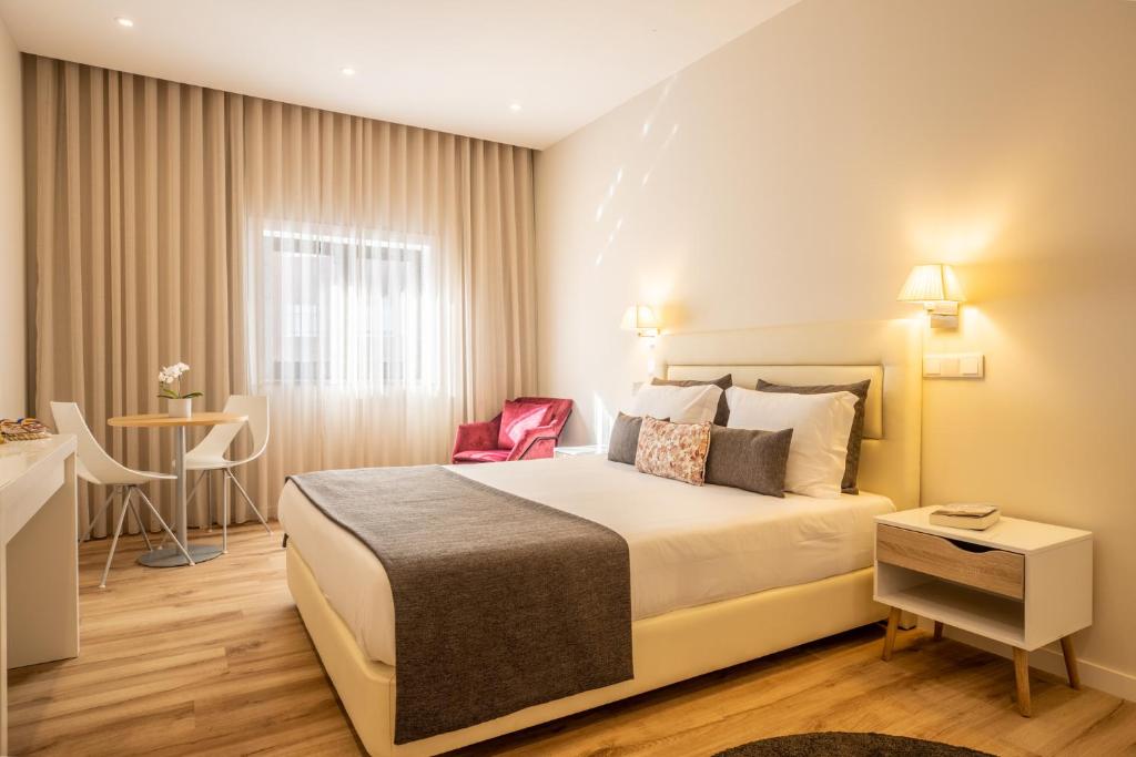 um quarto de hotel com uma cama e uma mesa em MyStay Matosinhos Centro em Matosinhos