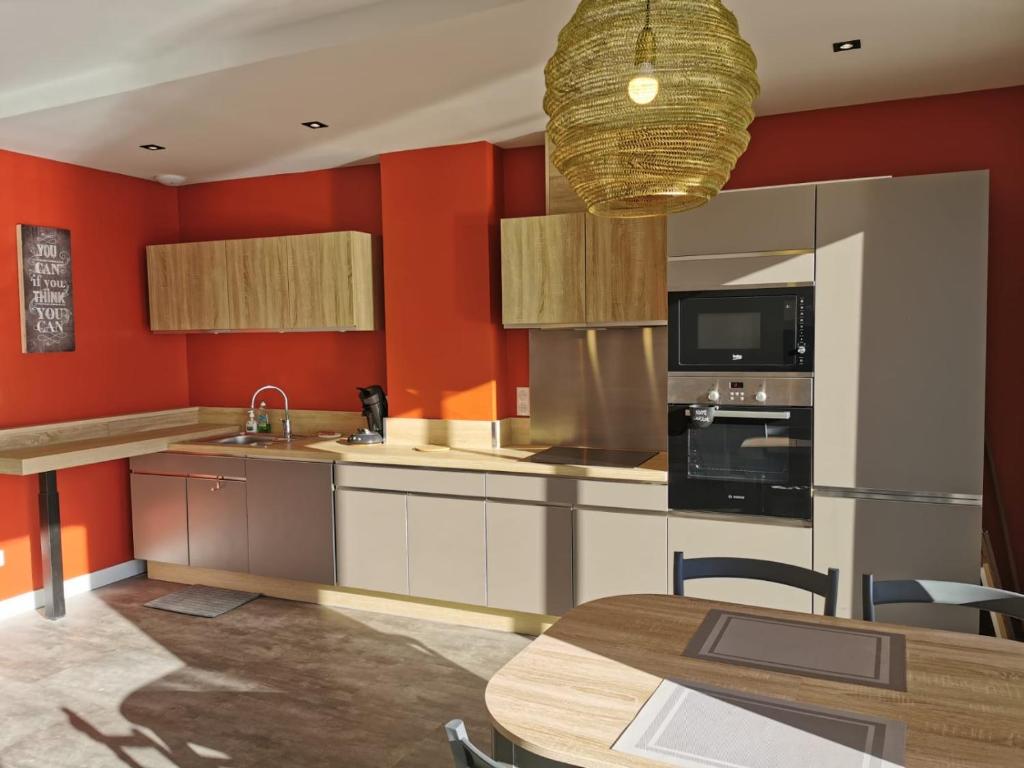 une cuisine aux murs rouges et une table avec des chaises dans l'établissement SETE VUE EXCEPTIONNELLE, à Sète