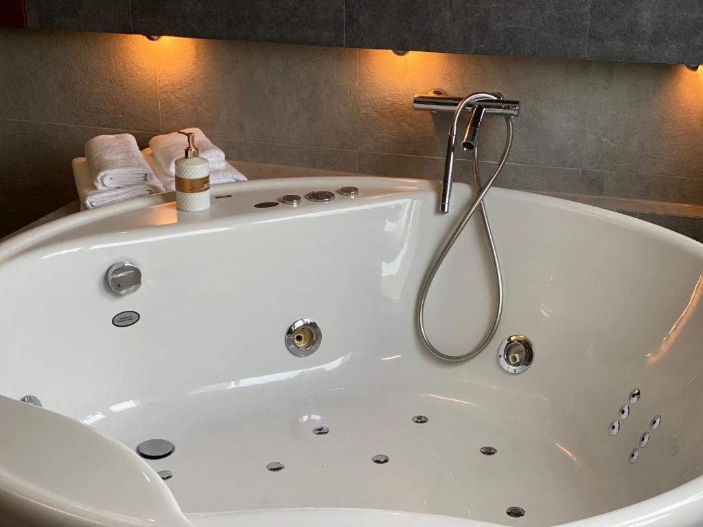 a white bath tub with a shower in a bathroom at Family & Business Sauna Apartments Klonowa nad Zalewem, Unikat SPA - 2 Bedroom with Private Sauna, Jacuzzi, Spectacular Terrace, Air Conditioning, Garage - The Highest Standard! in Kielce