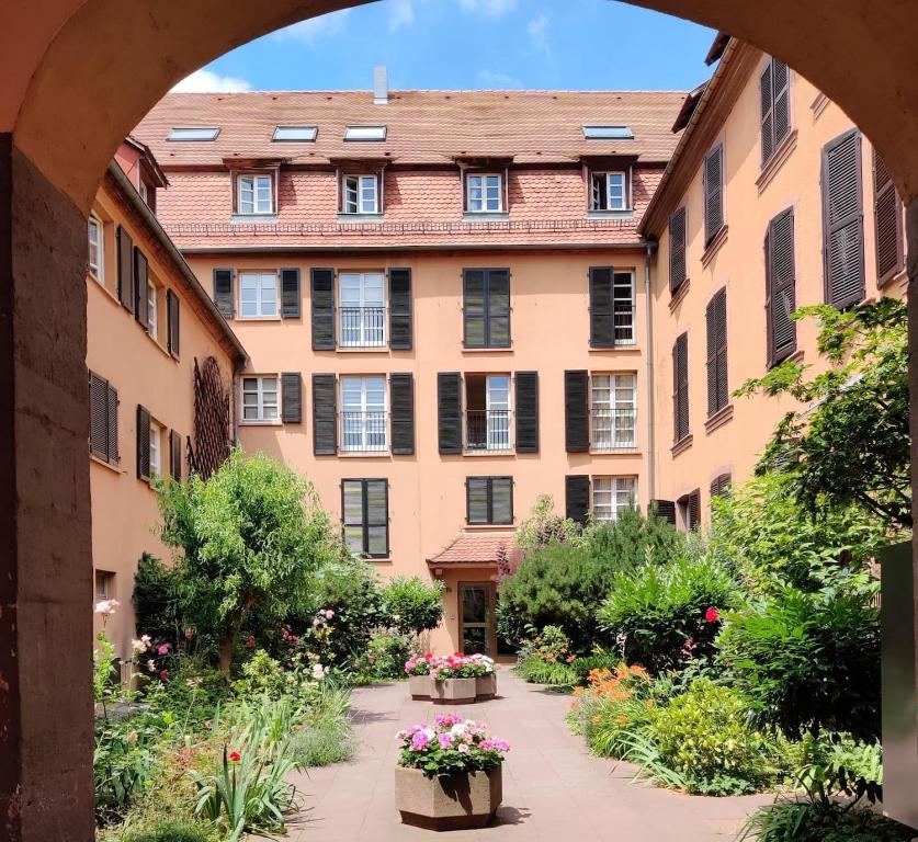 une vue sur la voûte d'un bâtiment fleuri dans une cour dans l'établissement Au Kugelhopf Doré - Centre Historique, à Colmar