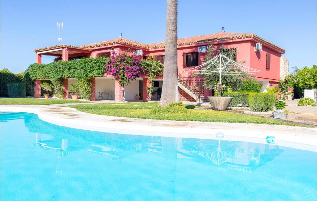 ein Haus mit einem Pool vor einem Haus in der Unterkunft Beautiful Home In Morn De La Frontera With Outdoor Swimming Pool in Morón de la Frontera