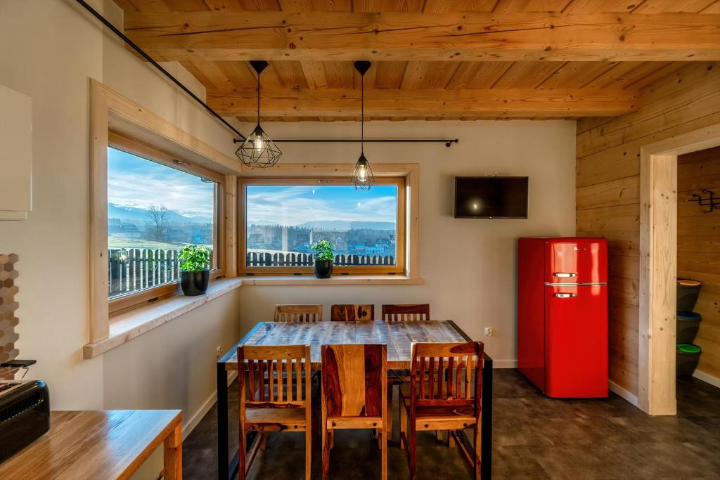 a dining room with a red refrigerator and a table at DOMEK W UBOCY z widokiem na Giewont "Jacuzzi i Sauna w ofercie dodatkowo płatnej" in Murzasichle
