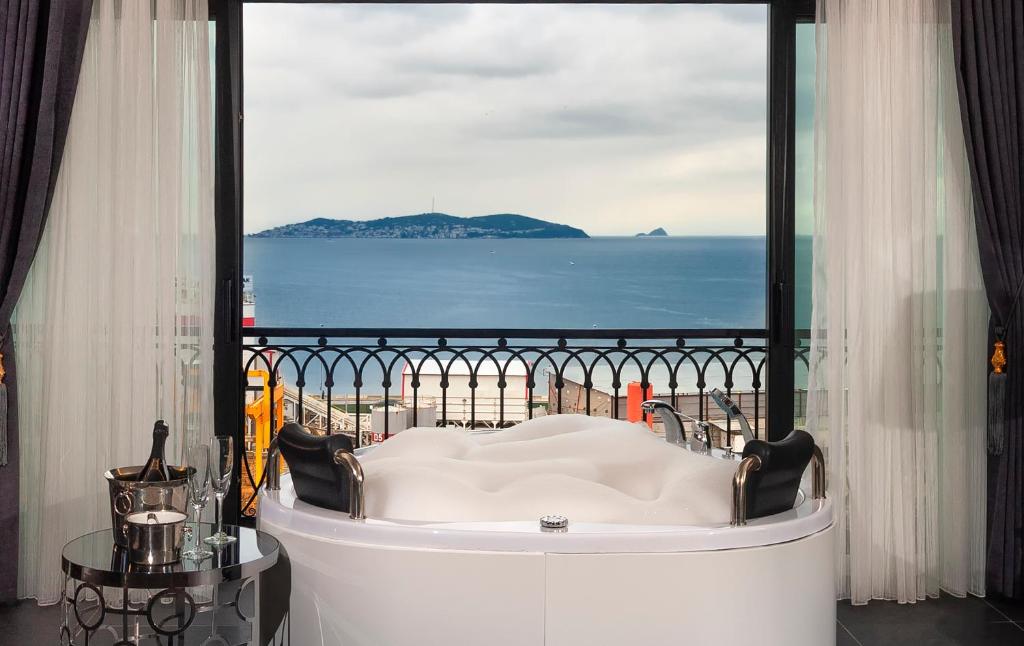 a bath tub in a room with a view of the ocean at La Cielo Hotel Bostancı in Istanbul