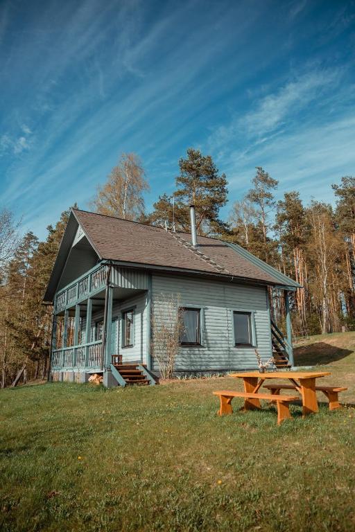 a house with a picnic table in front of it at Rāznas Stāvkrasti in Kaunata