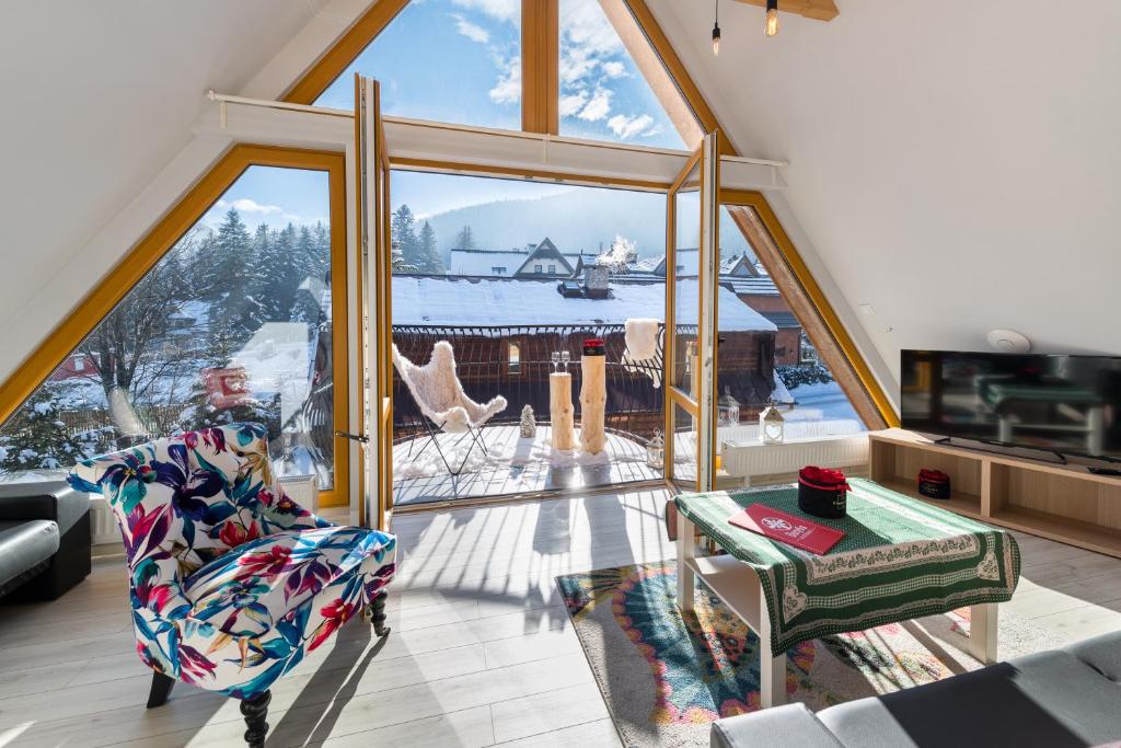a living room with a large window with a view at Bory6a Apartamenty in Zakopane
