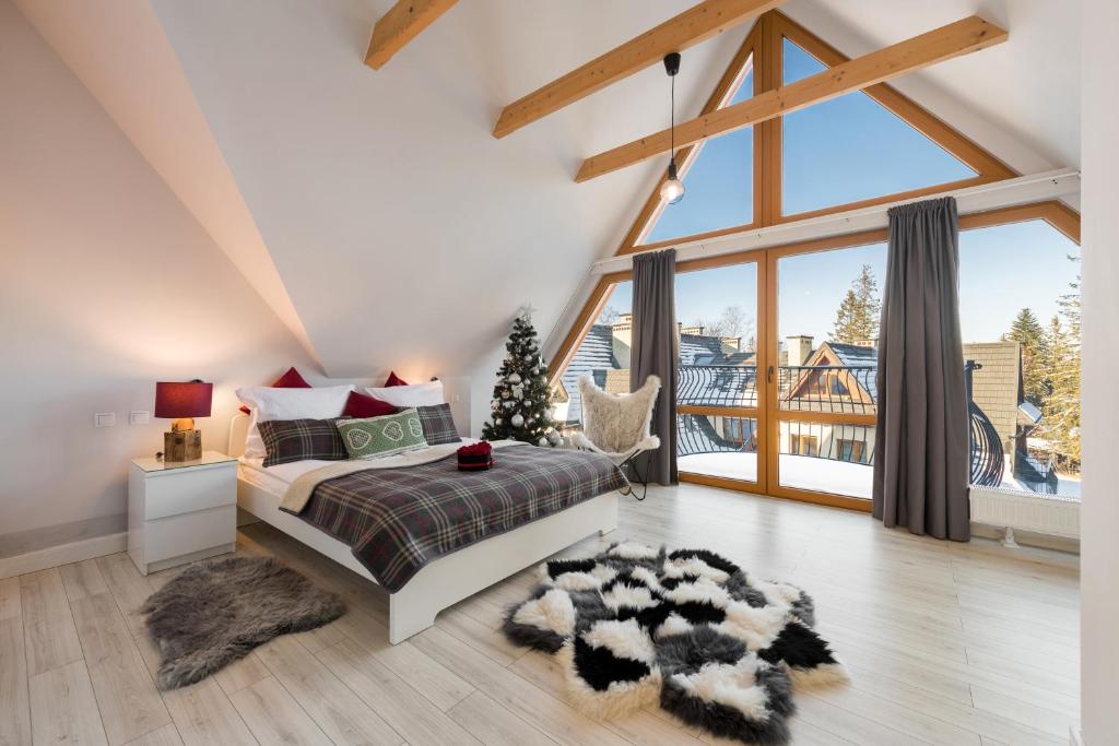 a bedroom with a bed and a large window at Bory6a Apartamenty & Free Parking in Zakopane
