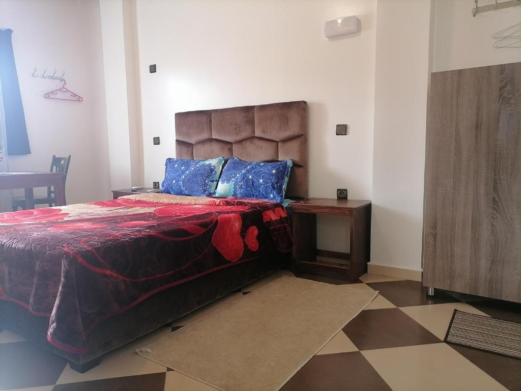 1 dormitorio con 1 cama grande y 1 mesa en ZELLAKA hôtel & café, en Khouribga