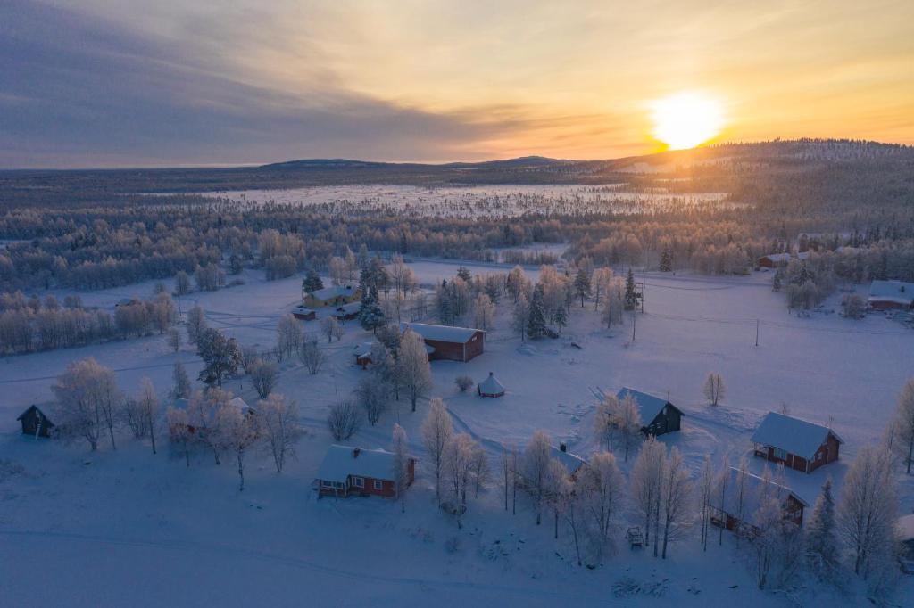 an aerial view of a village in the snow at sunset at Wild Stay - Ounasrannan majat, Tepasto in Tepasto