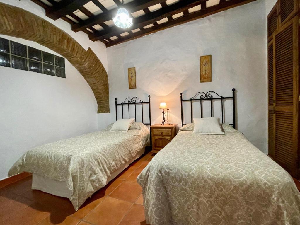 ヒメナ・デ・ラ・フロンテラにあるCasa Rural El Zaguánのベッド2台が隣同士に設置された部屋です。