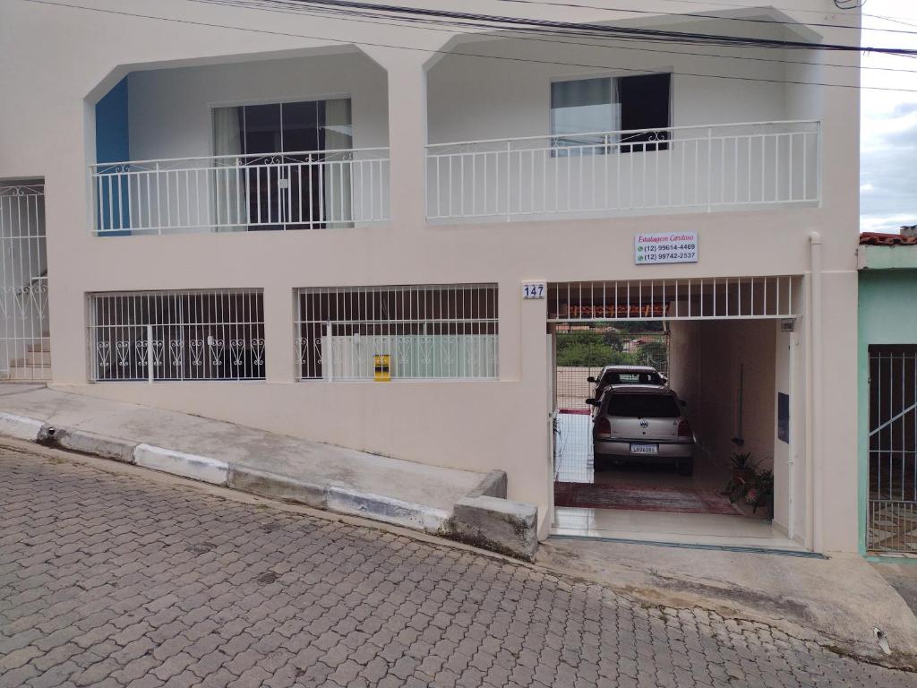 ein weißes Haus mit einem Auto in der Garage in der Unterkunft Estalagem Cardoso in Cunha