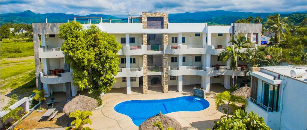 an aerial view of a large white building with a swimming pool at Real del Sol in Rincon de Guayabitos