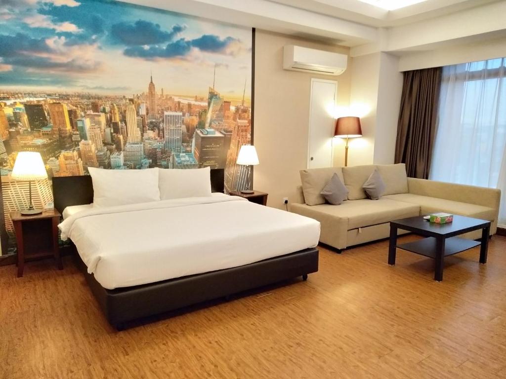 Habitación de hotel con 2 camas y sofá en Grand Service Apartment @ Times Square en Kuala Lumpur