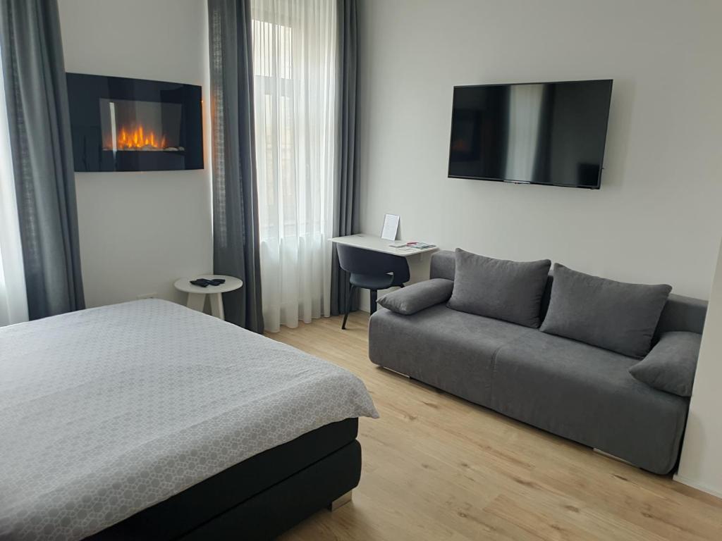 sypialnia z łóżkiem, kanapą i telewizorem w obiekcie City Center Main Square Apartments Zagreb w Zagrzebiu