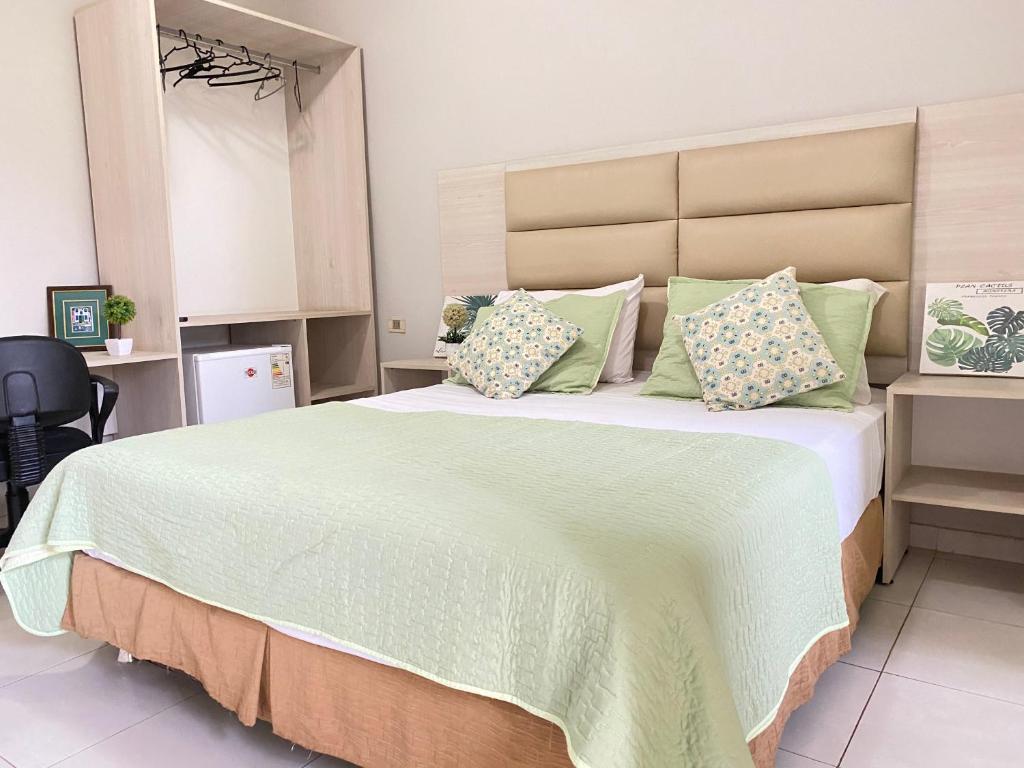 1 dormitorio con 1 cama grande con almohadas verdes en Canarias Bed & Breakfast, en San Lorenzo