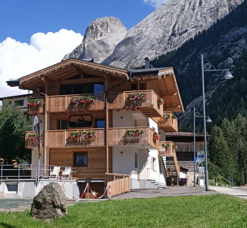 a log building with a mountain in the background at Piccola Cesa B&B in Canazei