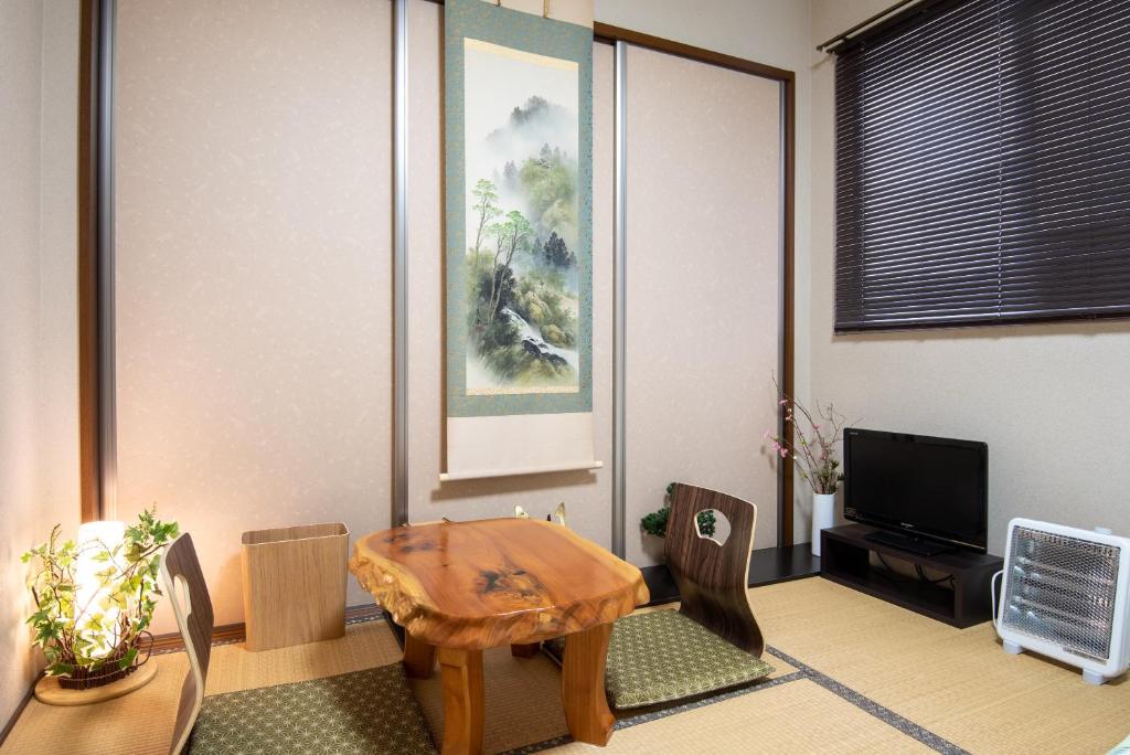 a living room with a wooden table and chairs at Garden Nikko Guest House in Nikko
