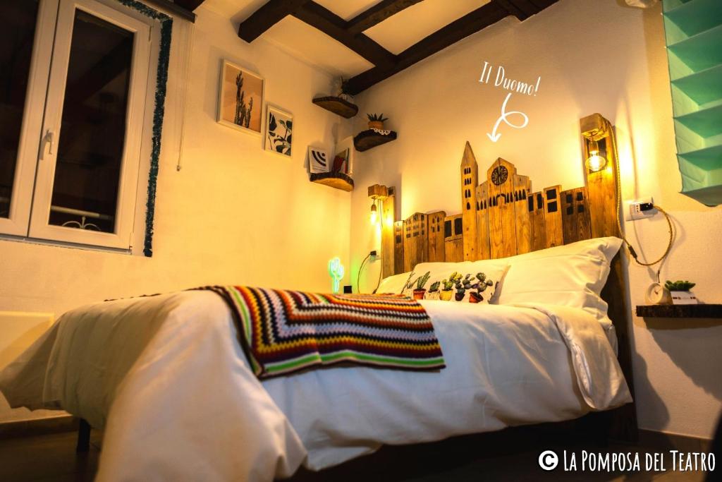 a bedroom with a bed with a white comforter at La Pomposa del Teatro in Modena