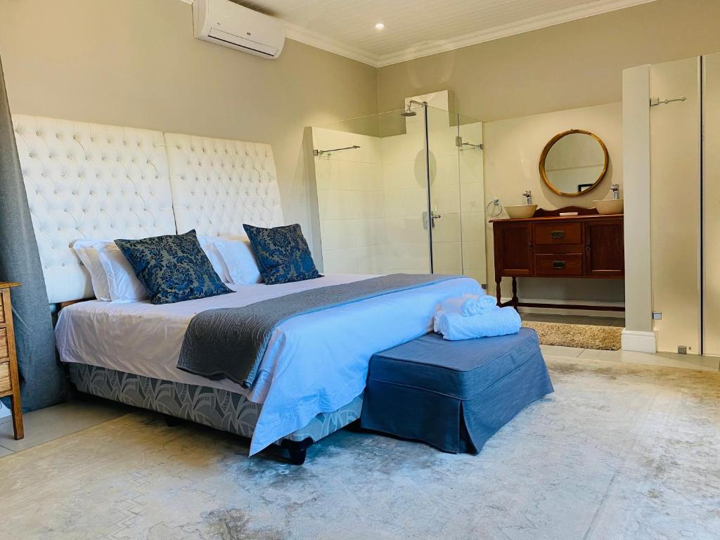 a bedroom with a large bed and a shower at Bonne Chance Cottage in Paarl