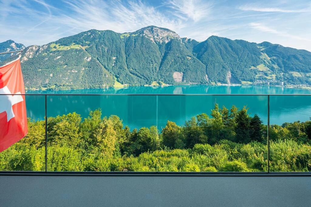 uma vista para um lago e montanhas com uma bandeira em Exklusives Chalet mit traumhafter See- und Bergsicht em Seelisberg