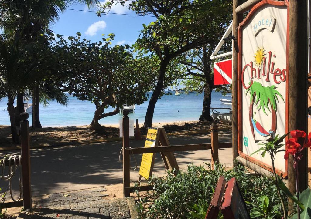 una señal en el lado de una playa en Hotel Chillies and Native Sons Diving, en West End