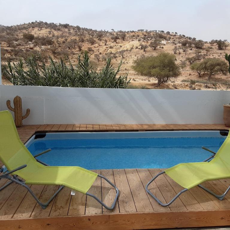 two chairs and a swimming pool on a deck at ESCALE PARADIS 10 pers 4 ch 3 sdb piscine in Aourir