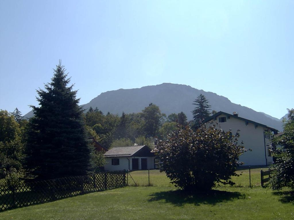 a house in a field with a fence and a tree at Haus Alpenblick inkl. Chiemgaukarte in Ruhpolding