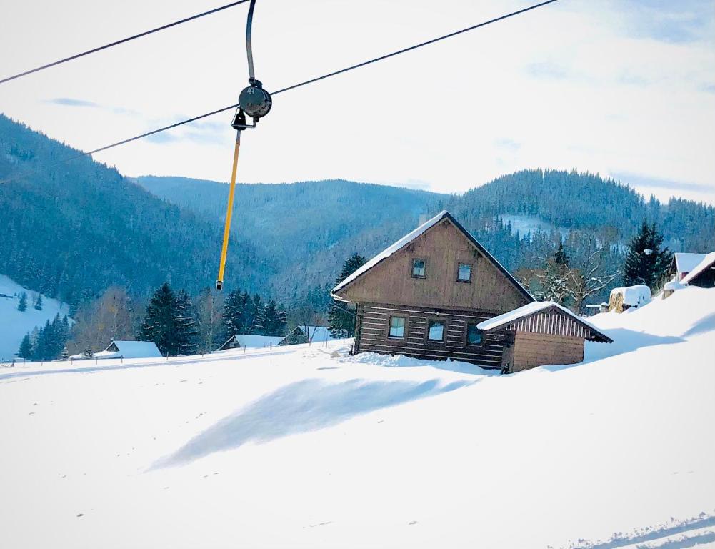 een huis op een besneeuwde heuvel met een skilift bij Apartmán U Setra in Pec pod Sněžkou
