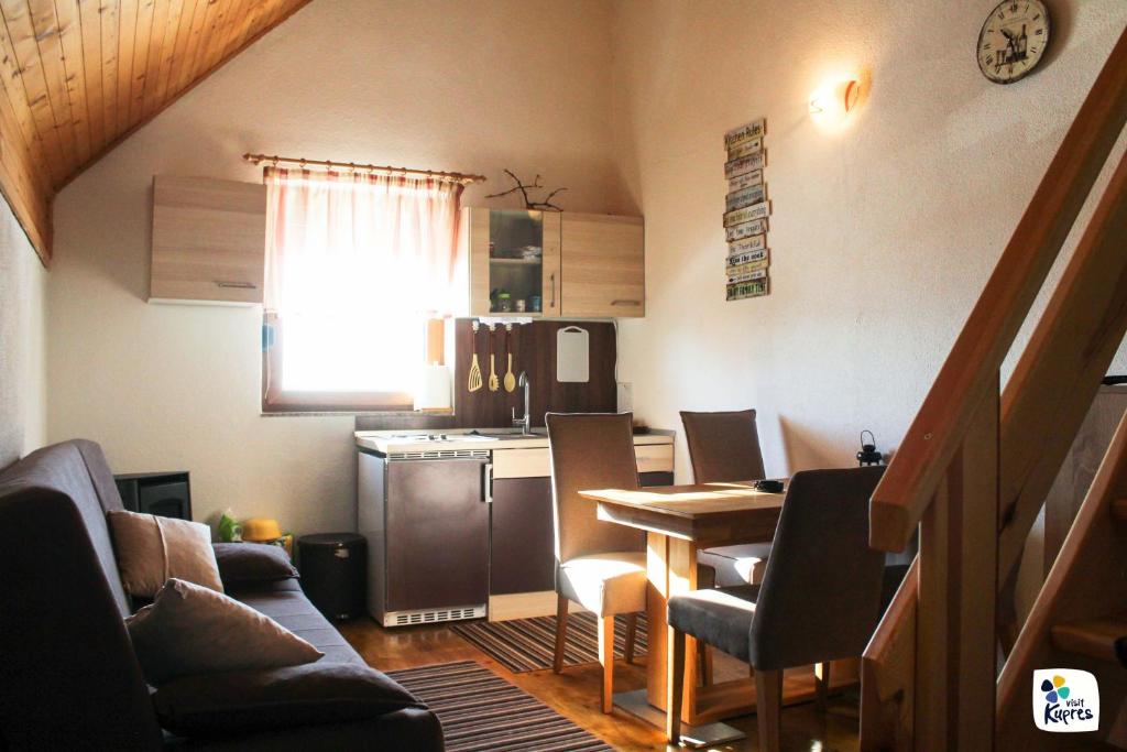 a living room with a table and a kitchen at Apartman Adria 2 in Kupres