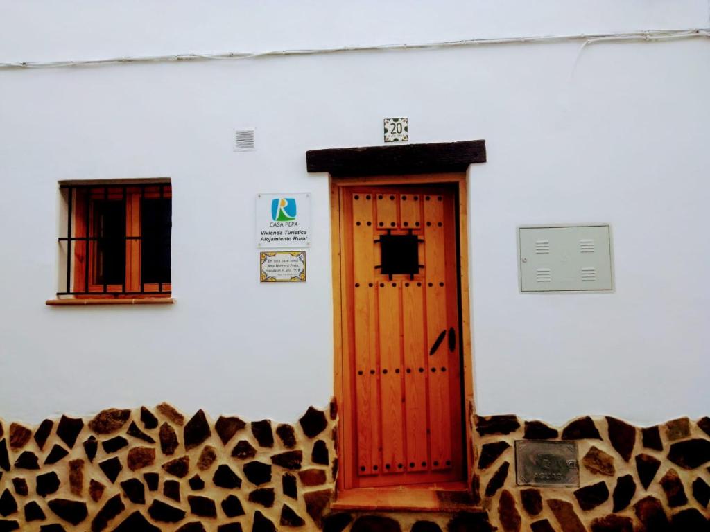 a room with a wooden door and a animal print wall at Casa Pepa in Algar