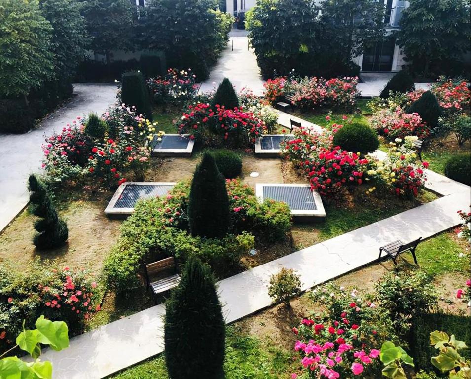 um jardim com flores e árvores e um banco em Appartement 6 pers. à Disneyland Paris em Chessy