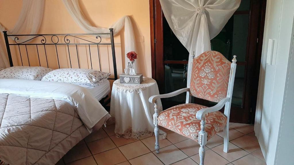 Hotel La Selce في مونسيليسي: غرفة نوم بسرير وكرسي وطاولة
