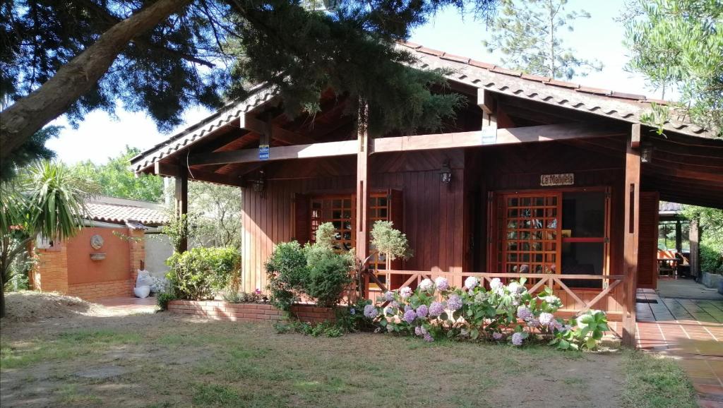 une petite maison avec des fleurs devant elle dans l'établissement La Manuela, à Piriápolis