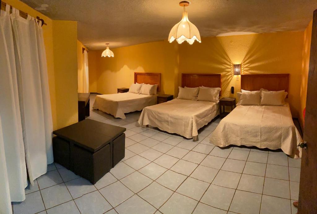 a hotel room with two beds and yellow walls at Hotel del Conde in Guanajuato