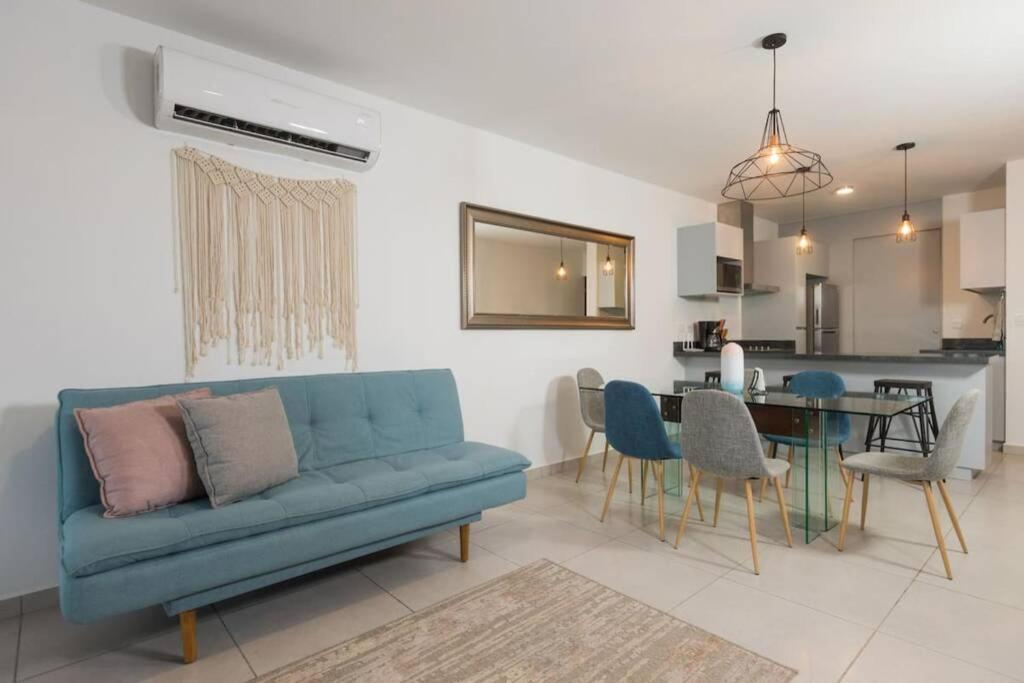 a living room with a blue couch and a table at DEPARTAMENTO EN PLANTA BAJA CON TERRAZA in Mazatlán