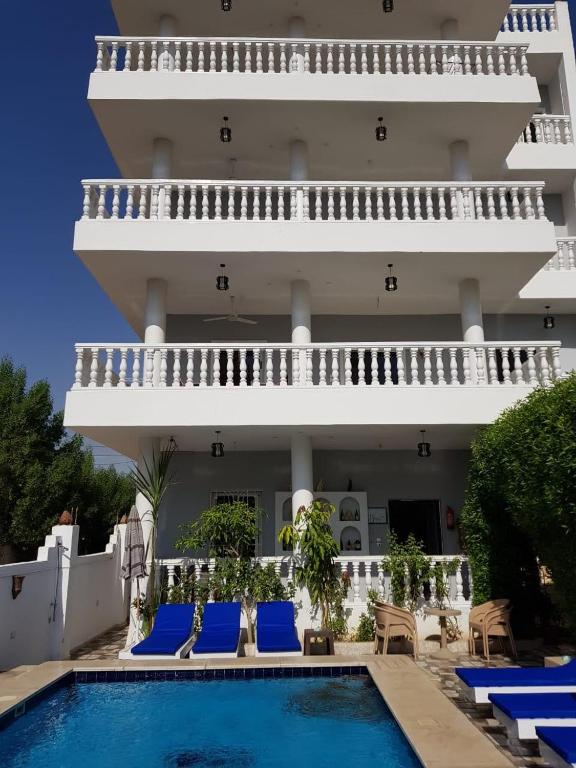 a villa with a swimming pool in front of a building at Luxor VIP Apartments in Luxor