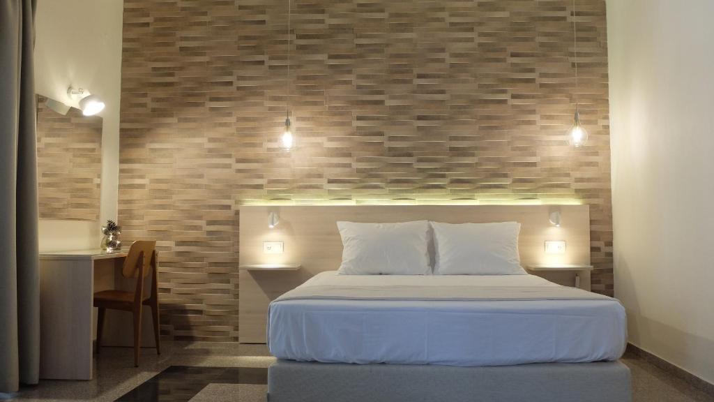 een slaapkamer met een bed met een bakstenen muur bij Elata-Apartments in Limenas