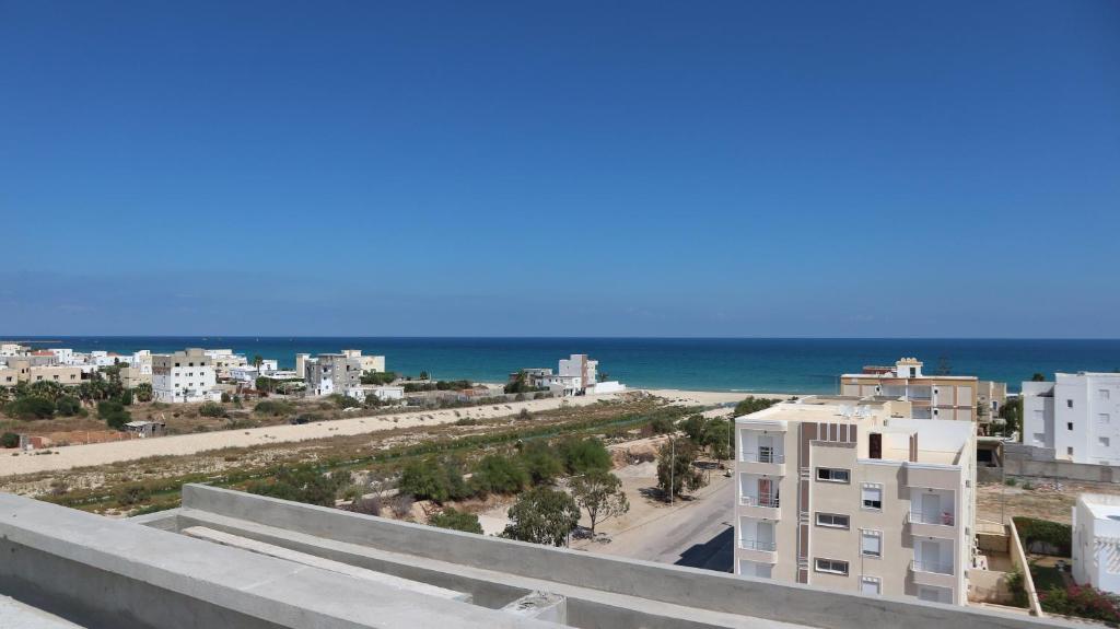 a view of the beach from the balcony of a building at Select Collection Hammam Sousse appartments in Sousse