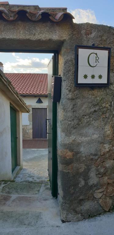 um sinal na lateral de um edifício de pedra em Casa Rural Las Canchaleras em Santibáñez el Alto