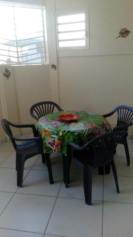 una mesa y sillas con un plato encima en résidences aux saveurs des mangues, en Baillif