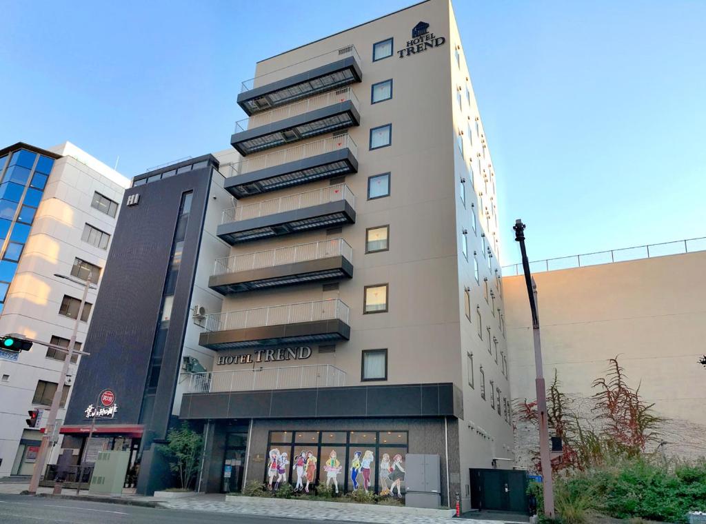 un edificio alto con una tienda delante en Hotel Trend Numazu Ekimae, en Numazu