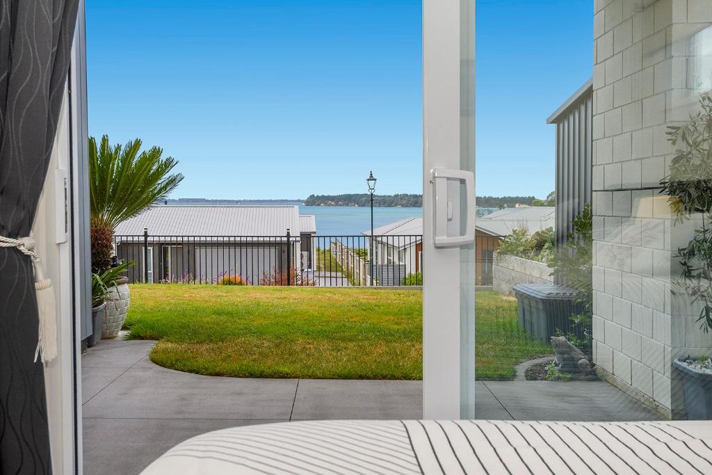 a view of a yard from the outside of a house at Omokoroa Sea View Apartment in Omokoroa