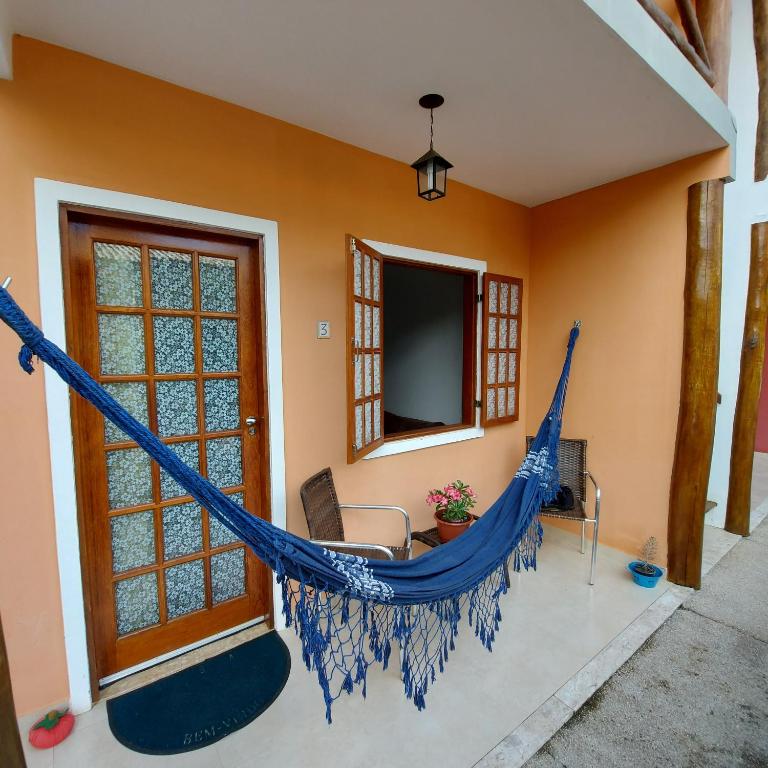 a hammock in a living room with a tv at Flat em Lençóis apartamento 003 in Lençóis