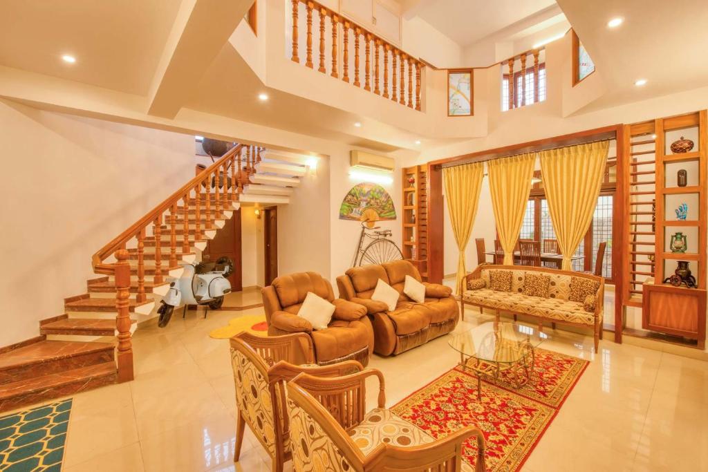 een woonkamer met meubilair en een trap bij StayVista at Chitrita Bhavan with Indoor Game & Free Breakfast in Pondicherry